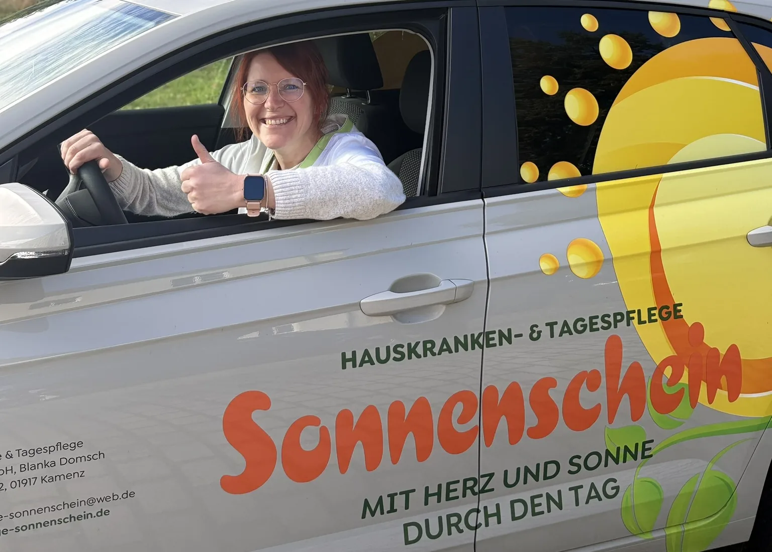 Mitarbeiterin des Pflegedienstes Sonnenschein im Dienstwagen mit Sonnenschein-Logo in Kamenz